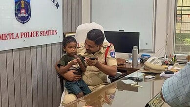 Police officer with young boy at Metla Police Station, India, during rescue operation.