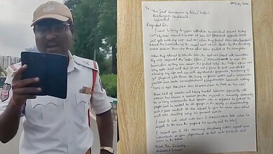 Police officer holding a tablet, speaking outdoors, with a handwritten letter in the background.