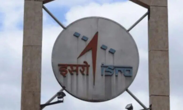 ISRO logo on a large circular signboard against a cloudy sky background.