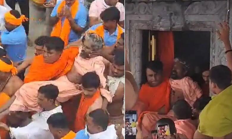 Hindu religious ceremony with priests and devotees inside a temple, performing rituals.