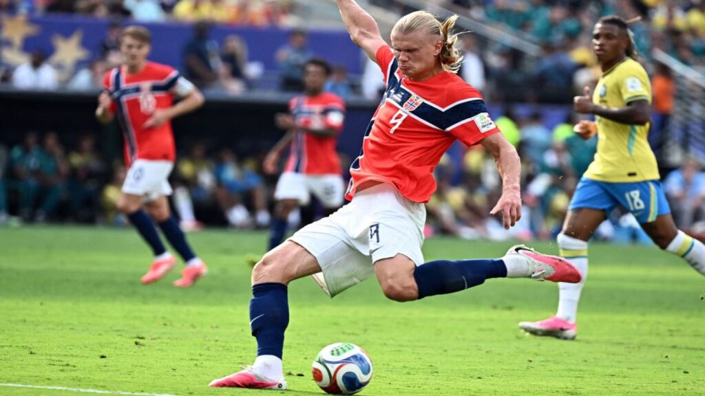 Norwegian footballer Erling Haaland scores a goal during a match against Brazil.