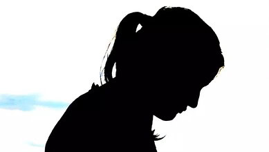 Silhouette of a girl with a ponytail looking down, against a white background.