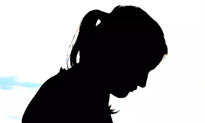 Silhouette of a girl with a ponytail looking down, against a white background.