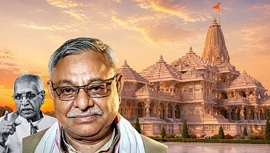Senior man with glasses in front of a Hindu temple at sunset.