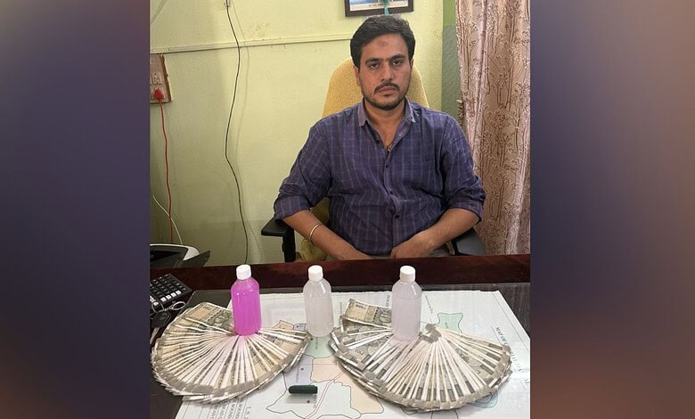 Tahsildar arrested for accepting Rs 70,000 bribe in Siddipet, sitting at desk with money and bottles.