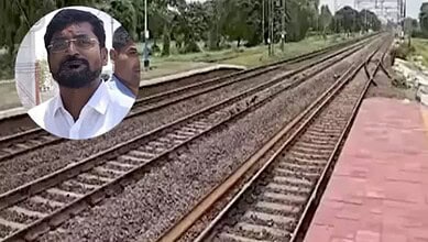 Man with glasses and beard near railway tracks in Telangana, India.