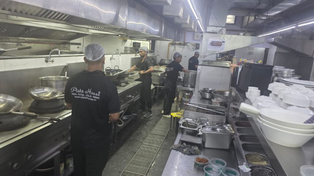 KFC Pista House food raid: Kitchen staff preparing food in a commercial kitchen.