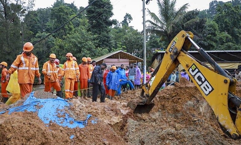 Construction workers and officials at a site with excavator and muddy terrain in a tropical area.