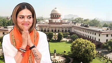 Indian woman in traditional attire with hands folded in front of the Supreme Court of India.