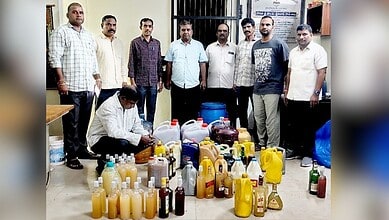 Group of men standing behind a collection of various bottles and containers in an indoor setting.