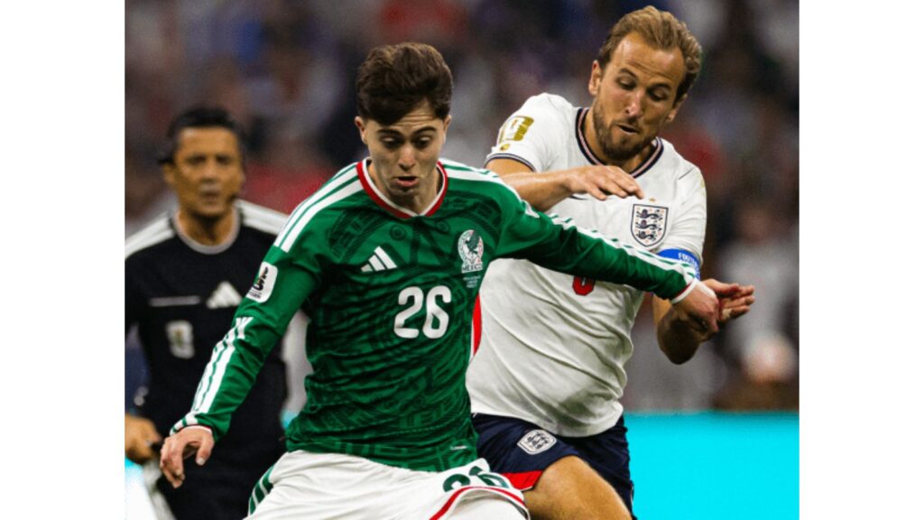 Mexican and English football players compete for the ball during a match.