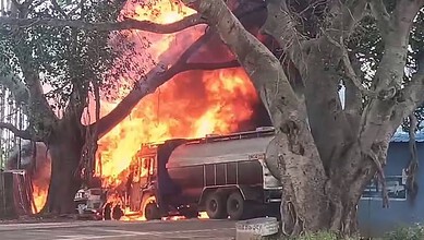 Petrol tanker on fire after crashing into a tree near Doddaballapur, with flames and smoke visible.
