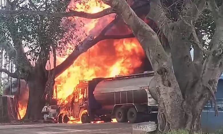 Petrol tanker on fire after crashing into a tree near Doddaballapur, with flames and smoke visible.