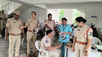 Police officers and medical staff engaged in a discussion in a parking area.