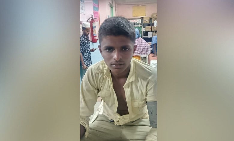 Young boy with serious expression in a classroom setting, wearing a light yellow shirt.