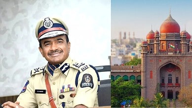 Indian police officer in uniform smiling, with a historic building in the background.