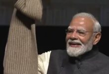 Indian Prime Minister Narendra Modi smiling and waving at a public event.