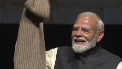 Indian Prime Minister Narendra Modi smiling and waving at a public event.