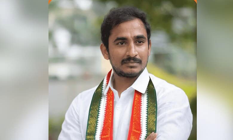 Man with a white shirt and tricolour scarf at a political event.