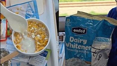 A bowl of cornflakes with spoiled milk and a spoon, on a train tray table.