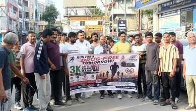 Group of people participating in a drug-free marathon awareness event on a busy street.