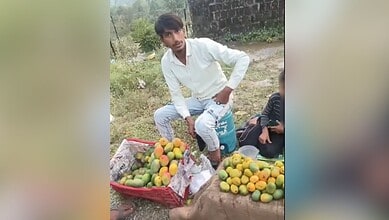 Young man selling mangoes on roadside in Uttarakhand, India.