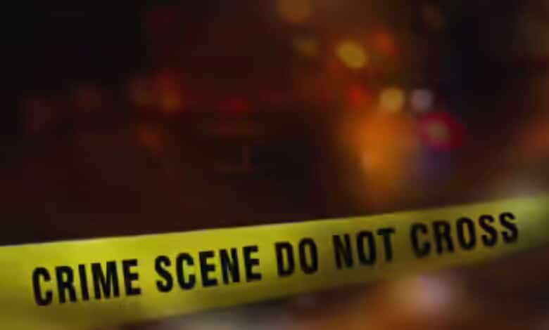 Crime scene tape with 'Crime Scene Do Not Cross' warning in focus, blurred background.