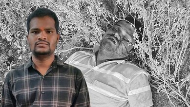 Two men, one standing and one lying down, in a black-and-white photo with dry foliage background.