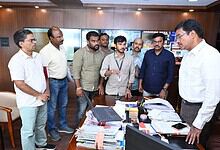 Group of officials discussing in office during the launch of online fire NOC portal.