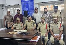 Police officers with seized cash and items in Hyderabad, related to theft case.