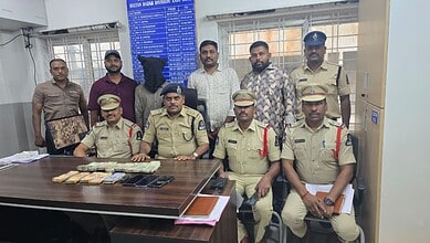 Police officers with seized cash and items in Hyderabad, related to theft case.
