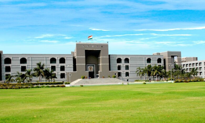 Modern government building with a large green lawn and palm trees in front, under a blue sky.