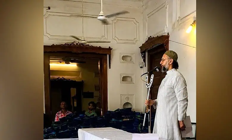 Asaduddin Owaisi speaking at a public event with a microphone in hand.