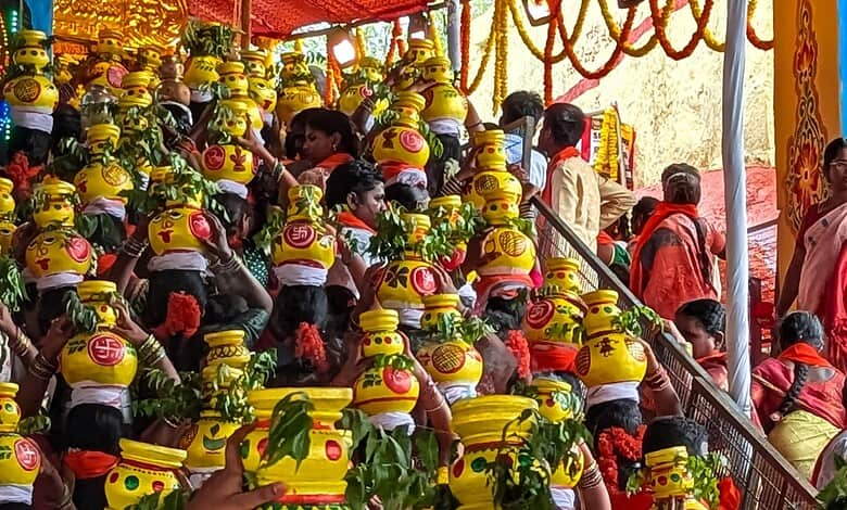 People participating in a traditional festival with decorated pots and vibrant attire.