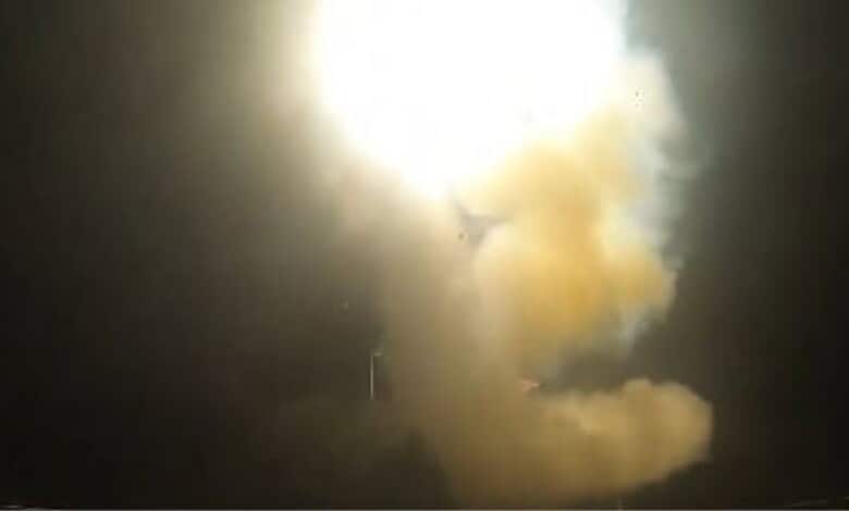 Explosion with smoke and fire during a military strike or missile launch at night.