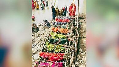 People lying on makeshift bamboo stretchers during a rescue operation at a flood site.