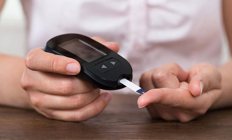 Person testing blood sugar levels with a glucometer for diabetes management.