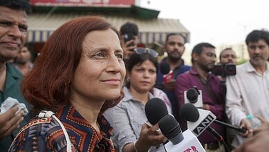 Wangchuk's wife speaking to media outside Safdarjung Hospital with reporters and microphones present.