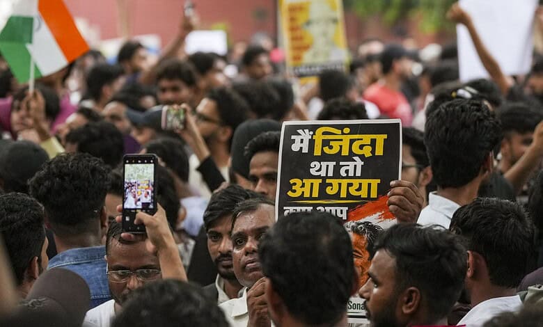 Protesters at Jantar Mantar hold signs during Chalo Sansad event in Delhi.