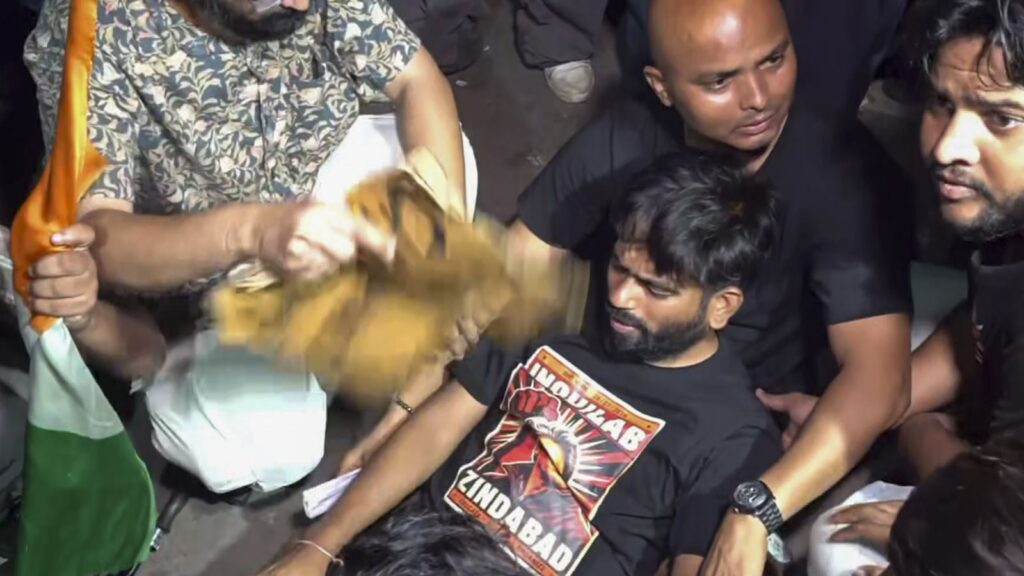 Protesters and police personnel injured during a clash, with some individuals on the ground and others in.