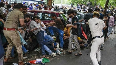 Clash between police and protesters causing chaos and injuries in a crowded street scene.