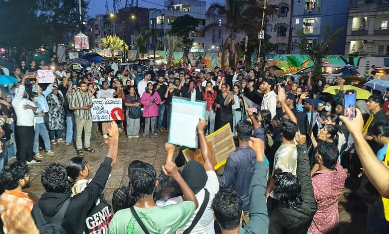 Protest in Hyderabad with large crowd holding signs and banners during evening.