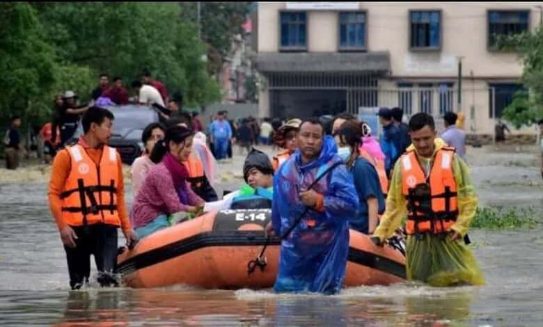 People use inflatable boats to eawde flood waters in Assam