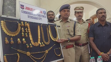 Police officers display gold jewelry recovered from theft in Hyderabad.