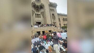 Hyderabad student leaders protest outside a historic building with banners and placards.