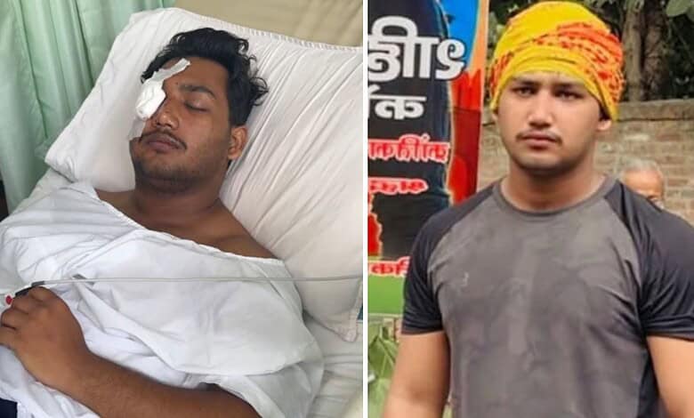Young man with a head injury lying in hospital bed, eyes closed, bandage on his forehead.