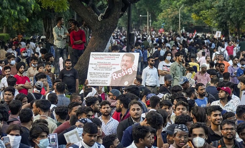 Large crowd of protesters with signs and banners during a demonstration in India.
