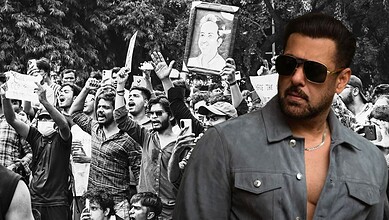 Salman Khan at a public event with a crowd of fans in the background.