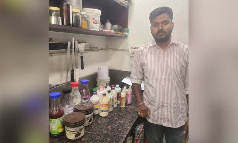 Hyderabad bakery owner standing in his shop with various ingredients and products on the shelves.