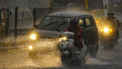 Motorcyclist and car navigating through heavy rain in Hyderabad, July 26-31.